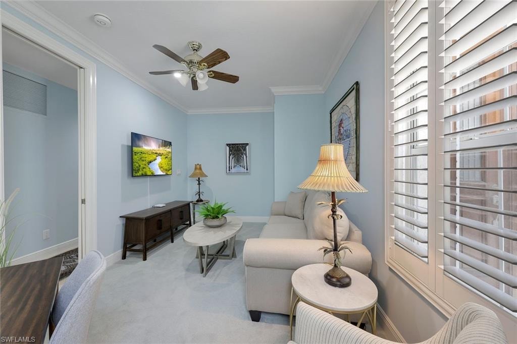 Sitting room featuring ornamental molding, carpet flooring, and ceiling fan