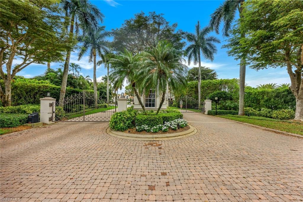 View of property's community featuring a gate and curved driveway