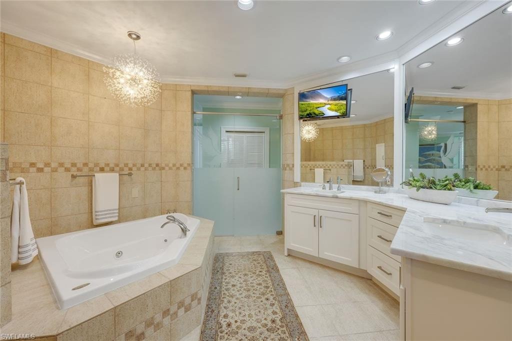 Bathroom featuring vanity, a stall shower, a whirlpool tub, tile walls, and light tile patterned floors