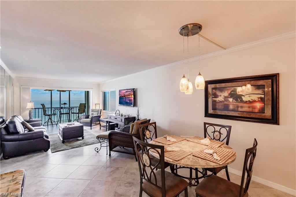 Dining room with crown molding, light tile patterned flooring, and floor to ceiling windows