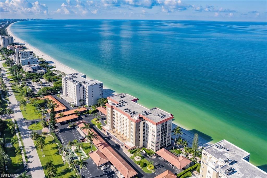 Drone / aerial view of waterfront with a beach and apartment complex / building
