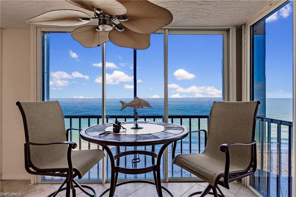 Sunroom featuring a wall of windows, a water view, plenty of natural light, and tile patterned floors