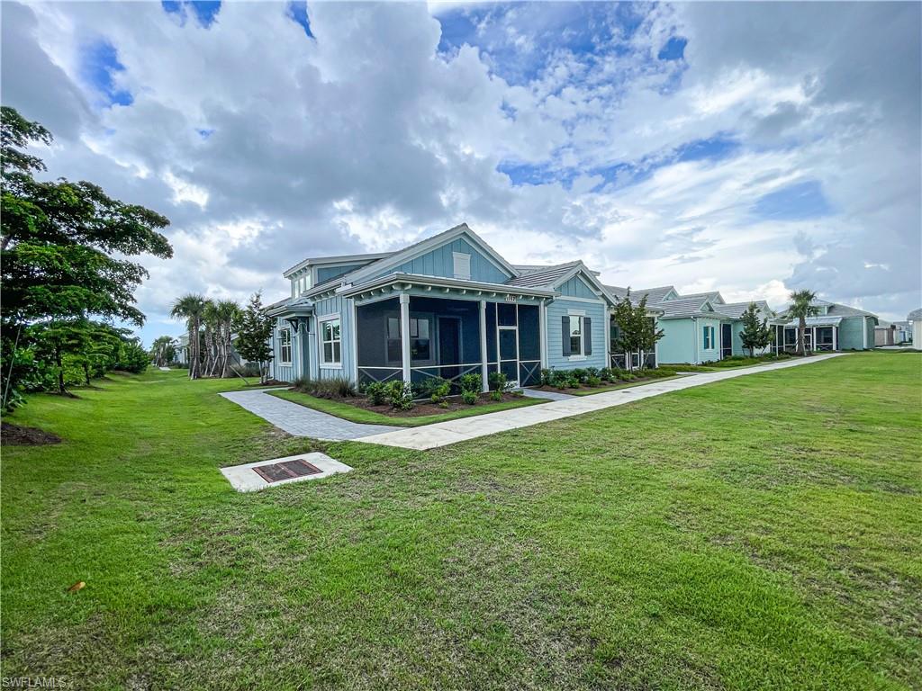 View of front facade featuring a sunroom and a front lawn