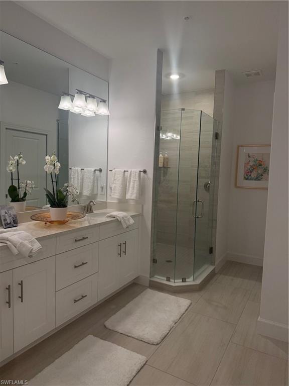Full bathroom featuring double vanity, a stall shower, and light tile patterned flooring