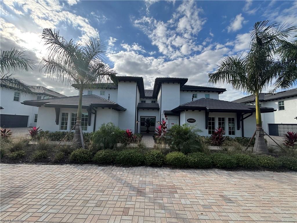 View of front facade with stucco siding and a tiled roof