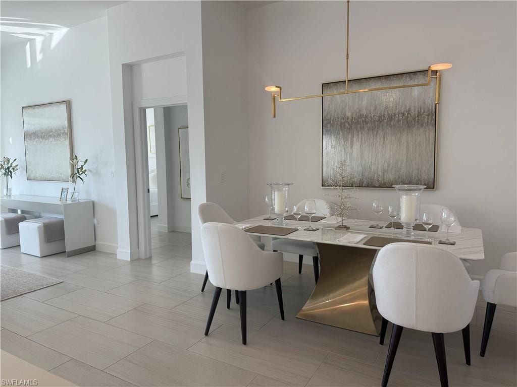 Dining space with baseboards and light tile patterned floors