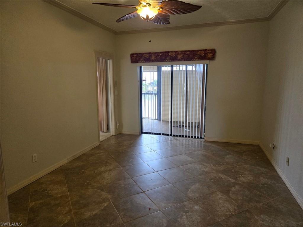 Master bedroom featuring ornamental molding, ceiling fan, and dark tile patterned floors