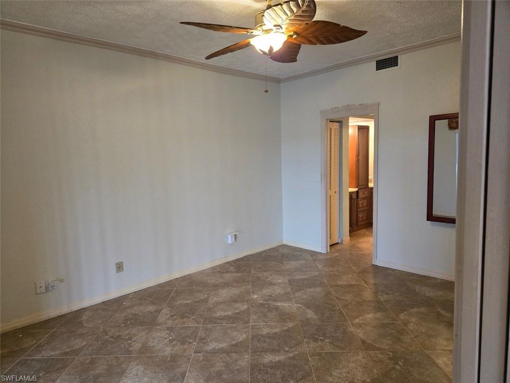 master bedroom with a textured ceiling, ornamental molding, and a ceiling fan