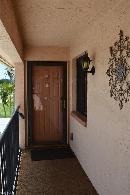 View of exterior entry featuring stucco siding