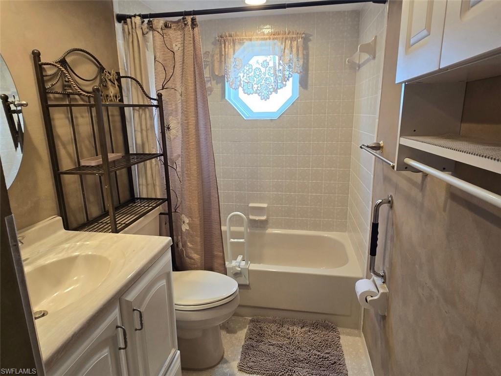 Bathroom with shower / bath combo with shower curtain and vanity