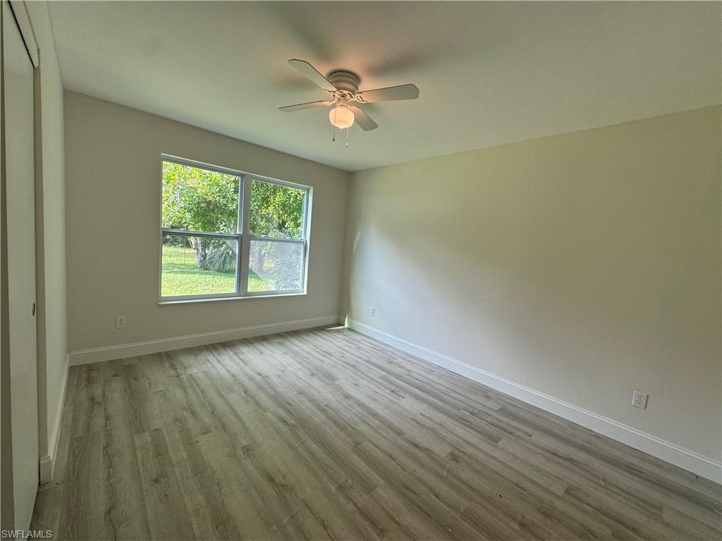 Empty room with light wood-style floors and ceiling fan