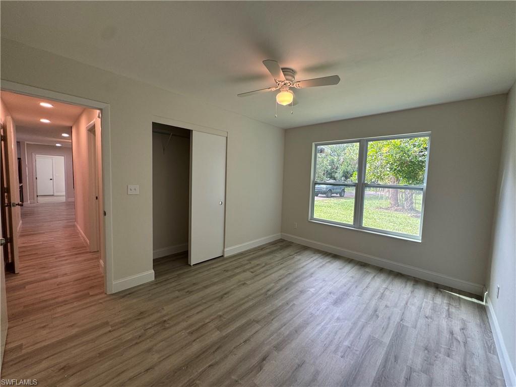 Unfurnished bedroom with light wood finished floors, ceiling fan, and a closet