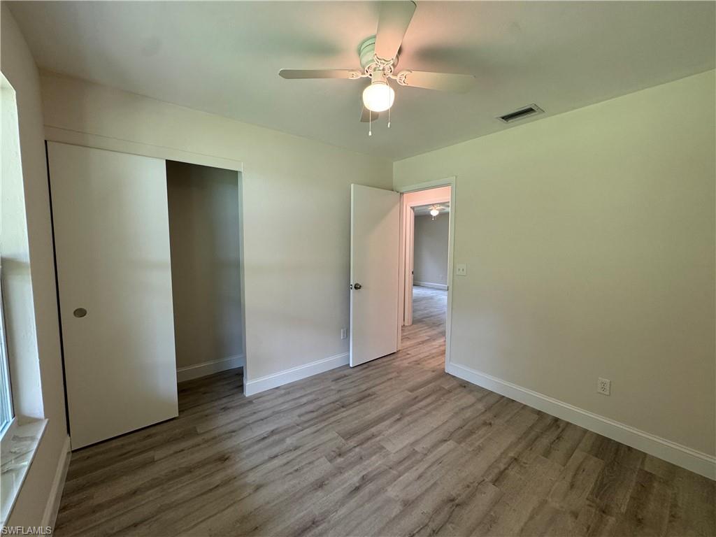Unfurnished bedroom with wood finished floors, ceiling fan, and a closet