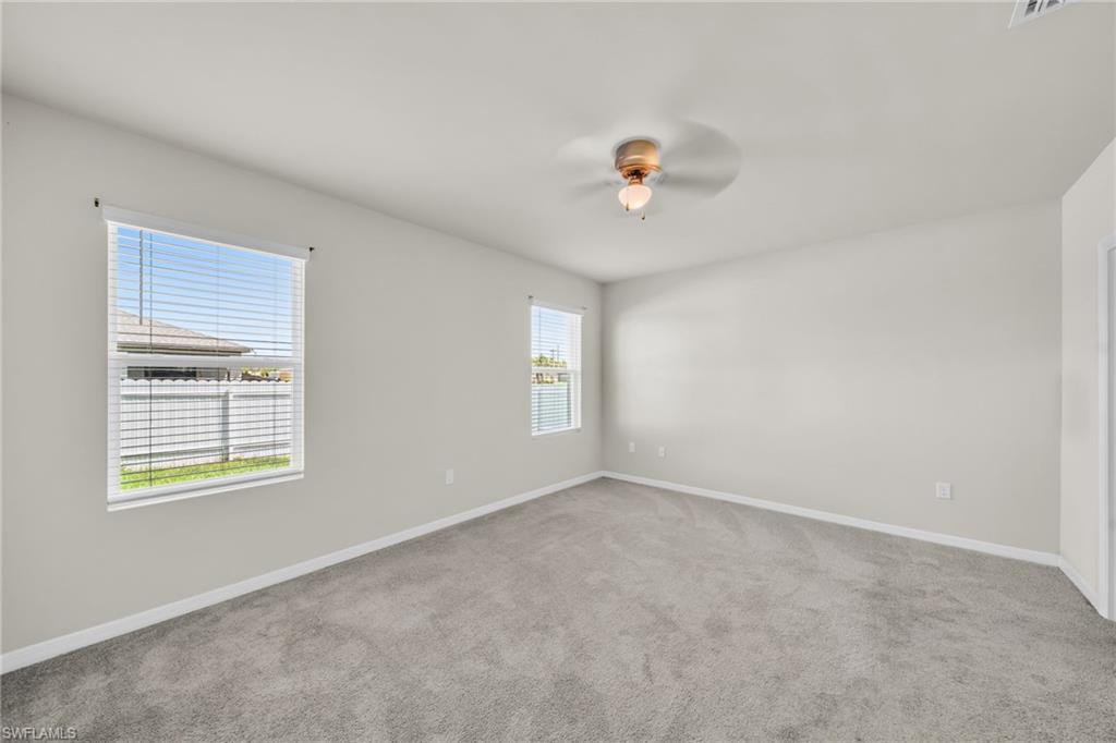 Unfurnished room with light colored carpet and ceiling fan
