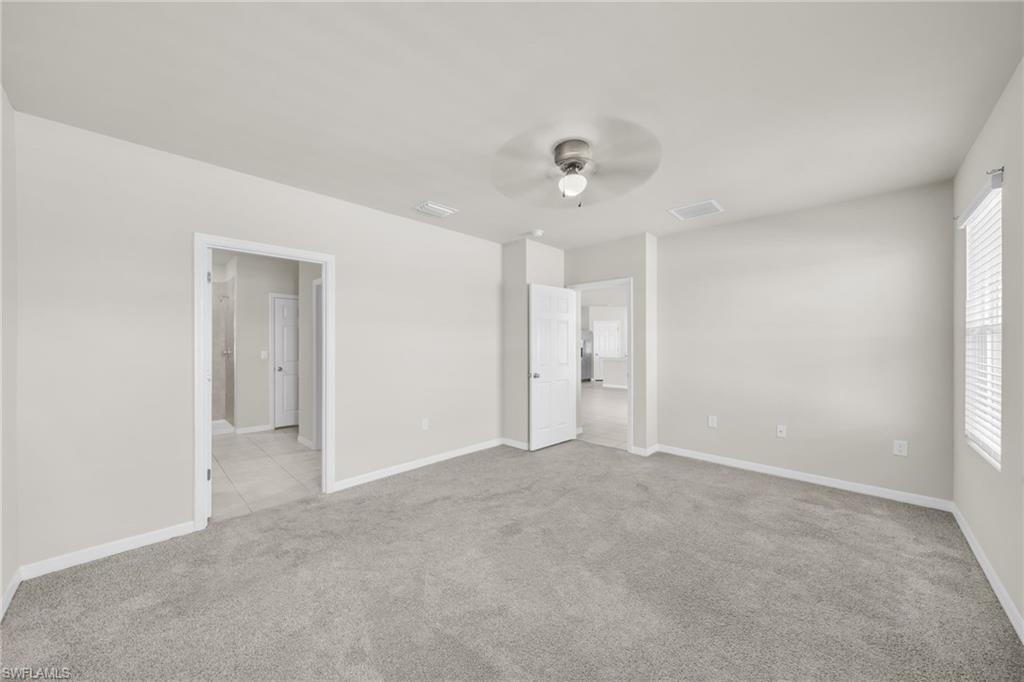 Unfurnished bedroom with light carpet and ceiling fan