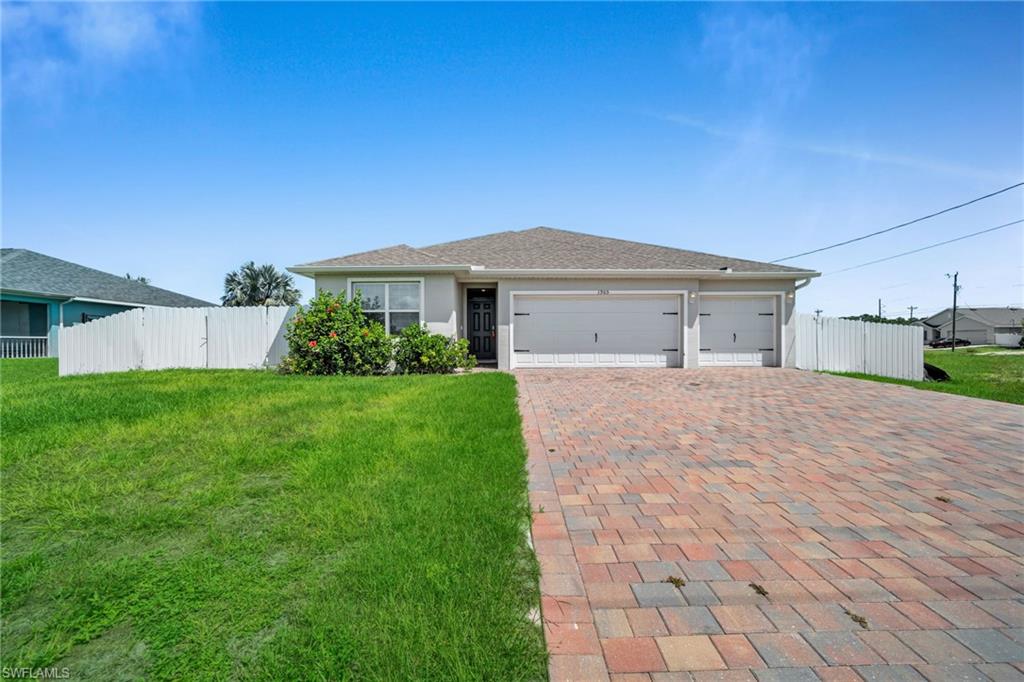 Ranch-style home featuring decorative driveway, a garage, and stucco siding