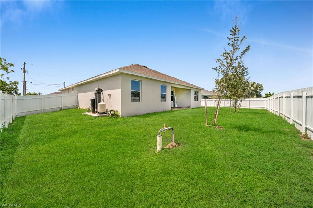 Rear view of property with a fenced backyard and stucco siding
