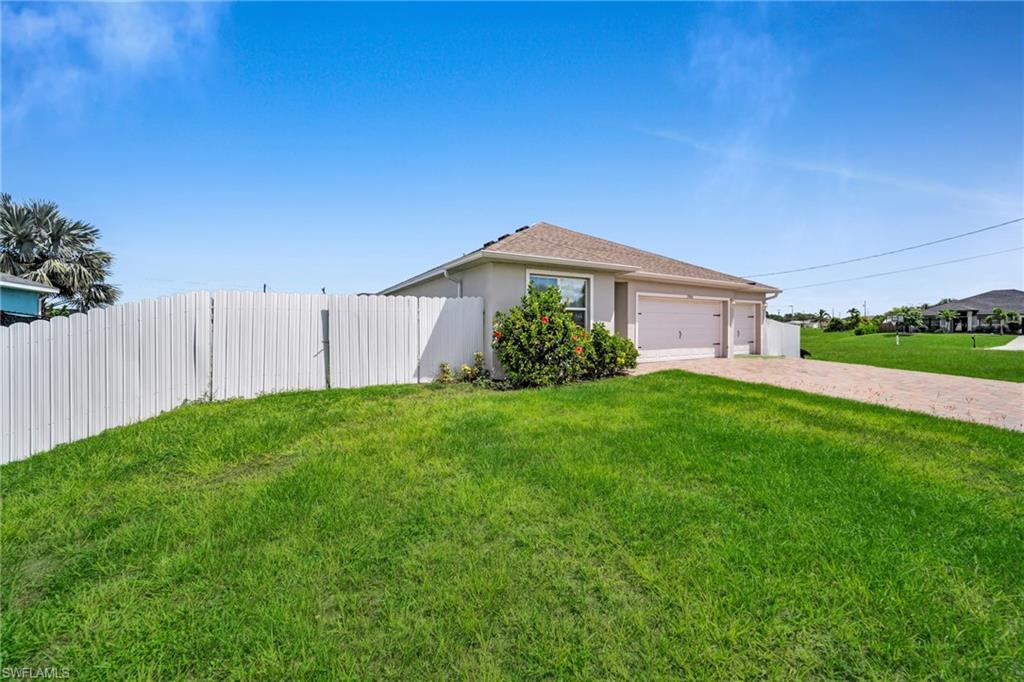View of front facade featuring decorative driveway, stucco siding, and an attached garage