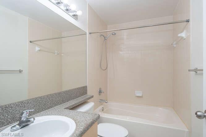 Full bathroom with shower / bath combination, oversized vanity, and toilet