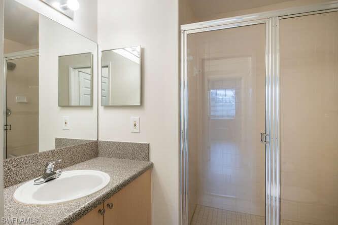 Bathroom with a shower with shower door and vanity