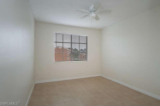Tiled empty room featuring ceiling fan