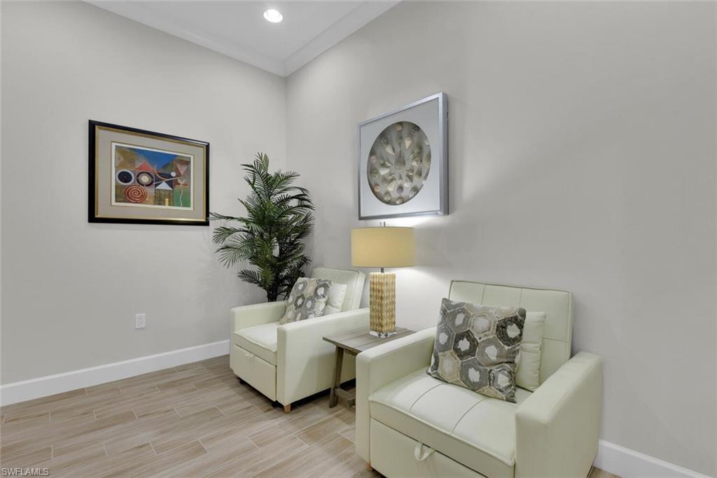 Living area featuring light wood-type flooring and ornamental molding