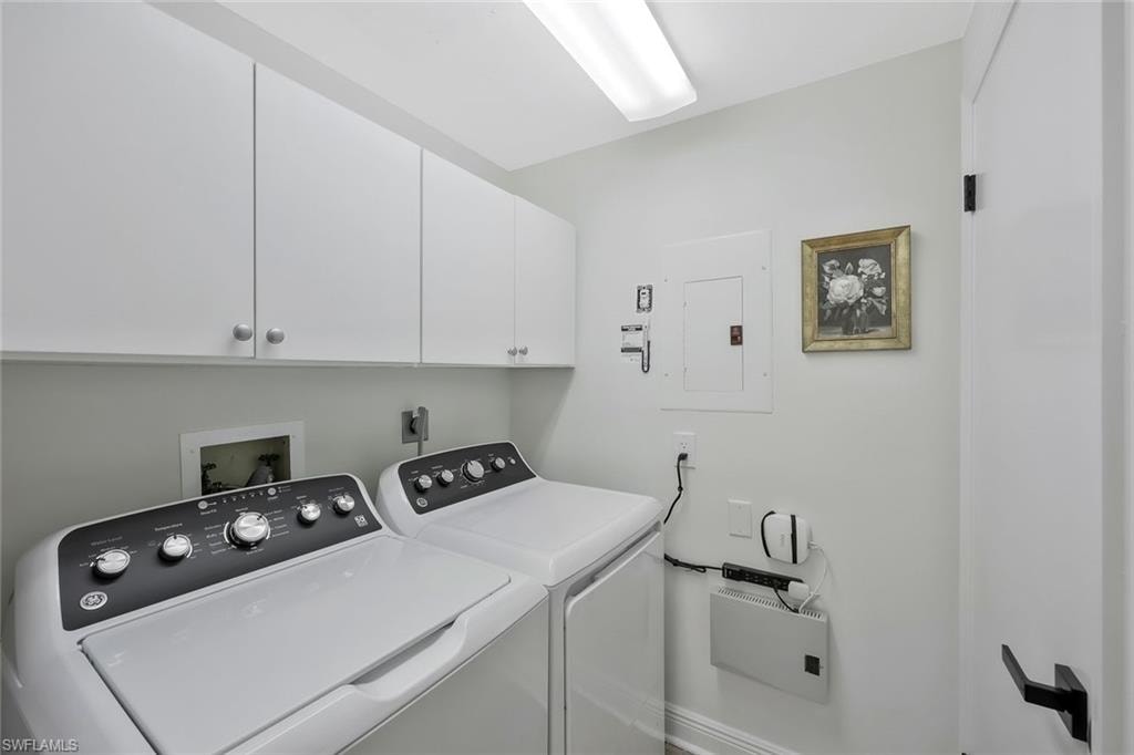 Laundry area with electric panel, washing machine and dryer, and cabinet space
