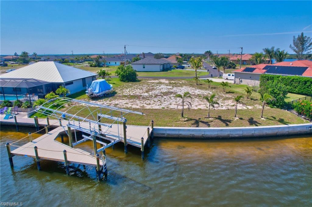 Dock with boat lift, a residential view, and a water view