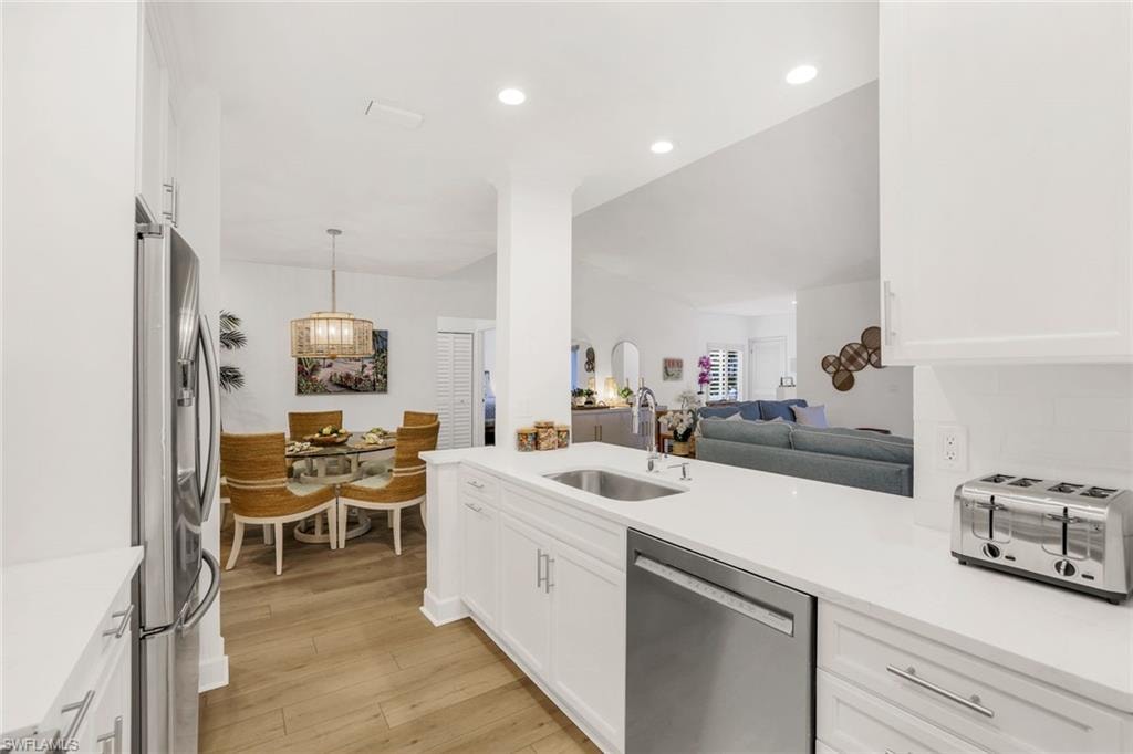 Kitchen featuring white cabinets, open floor plan, stainless steel appliances, and recessed lighting