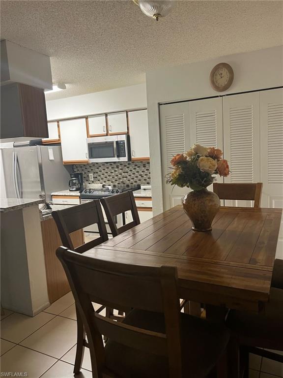 Dining area featuring light tile patterned flooring and a textured ceiling