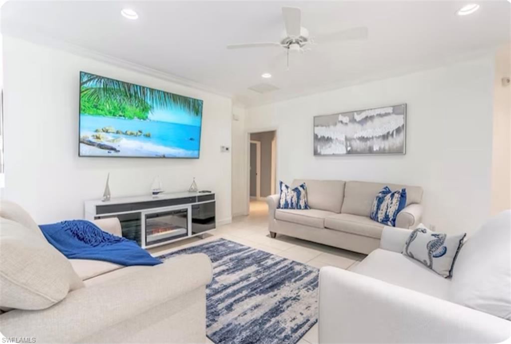 Living room with light tile patterned flooring, recessed lighting, and a ceiling fan