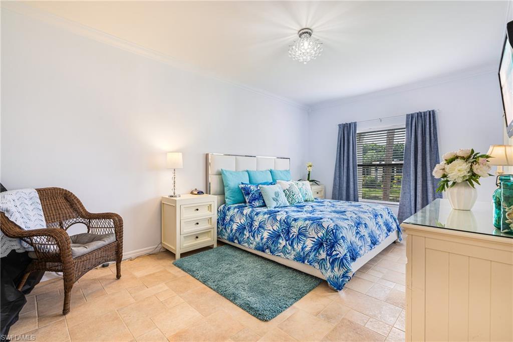 Bedroom featuring crown molding and stone finish flooring