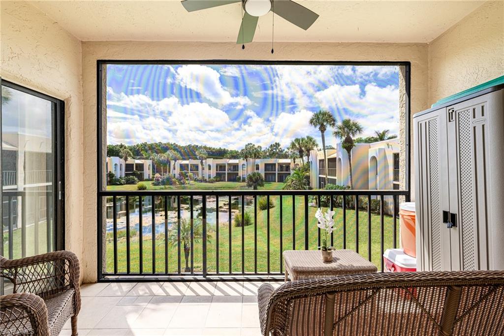 Balcony featuring ceiling fan and a water view