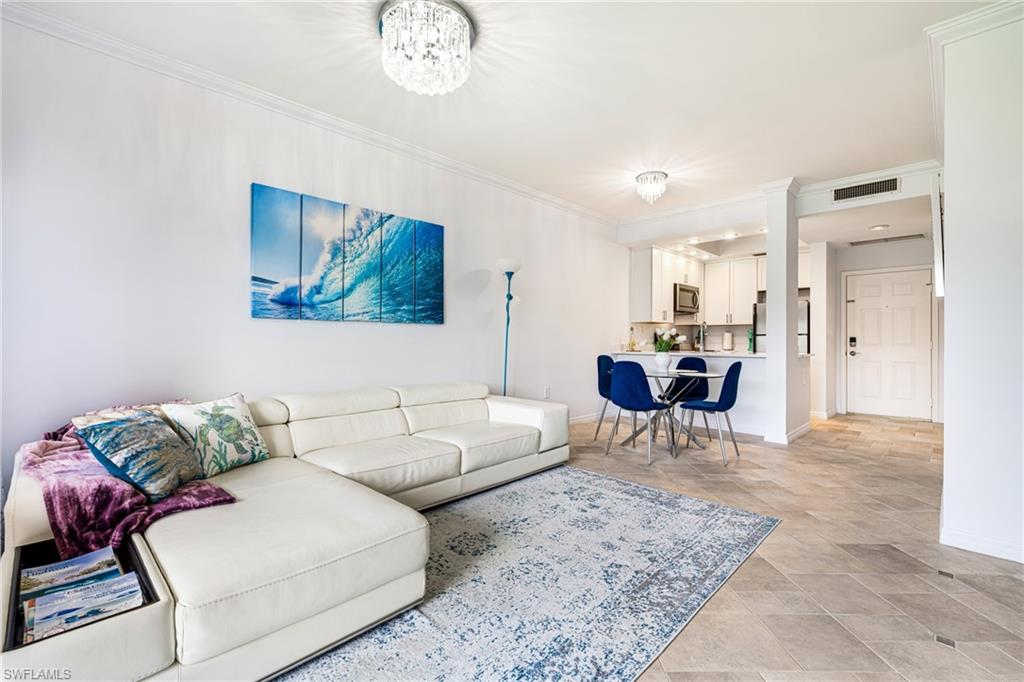 Living area with crown molding and a chandelier