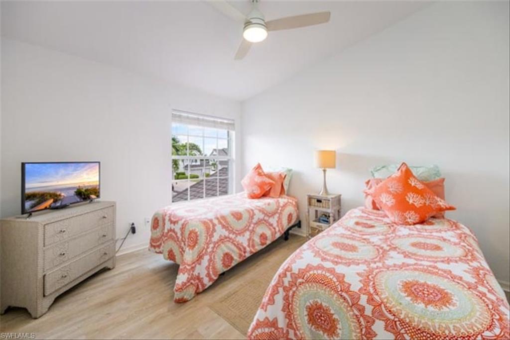 Bedroom featuring ceiling fan, light hardwood / wood-style flooring, and lofted ceiling