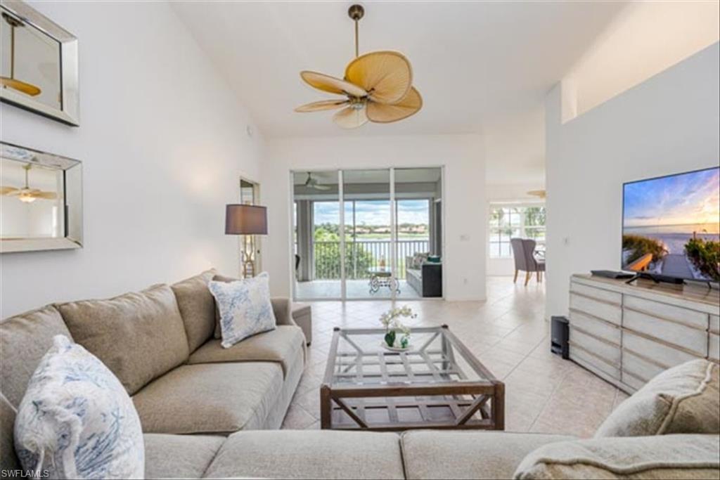 Tiled living room featuring high vaulted ceiling and ceiling fan