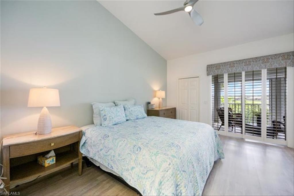 Bedroom with a closet, hardwood / wood-style flooring, access to exterior, lofted ceiling, and ceiling fan