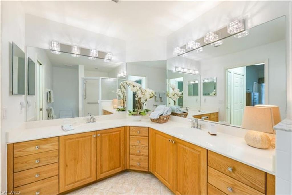 Bathroom with vanity, tile patterned flooring, a shower with shower door, and toilet