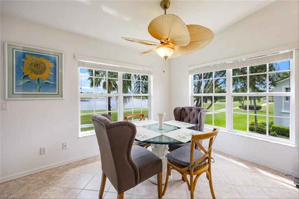 Tiled dining area with ceiling fan and lofted ceiling