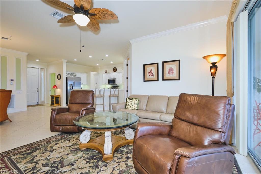 Living area with light tile patterned floors, ornamental molding, ceiling fan, and recessed lighting