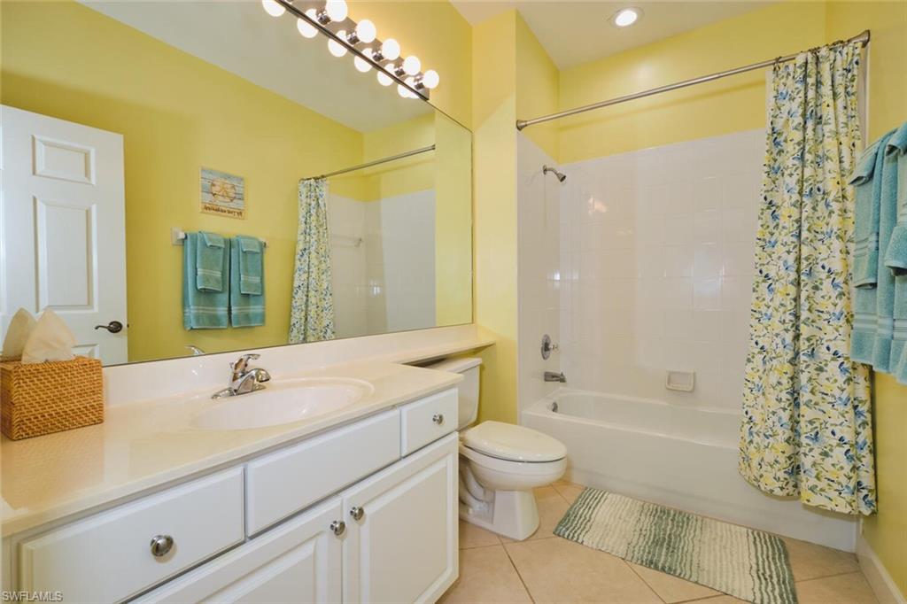 Full bath with shower / tub combo, light tile patterned flooring, and vanity
