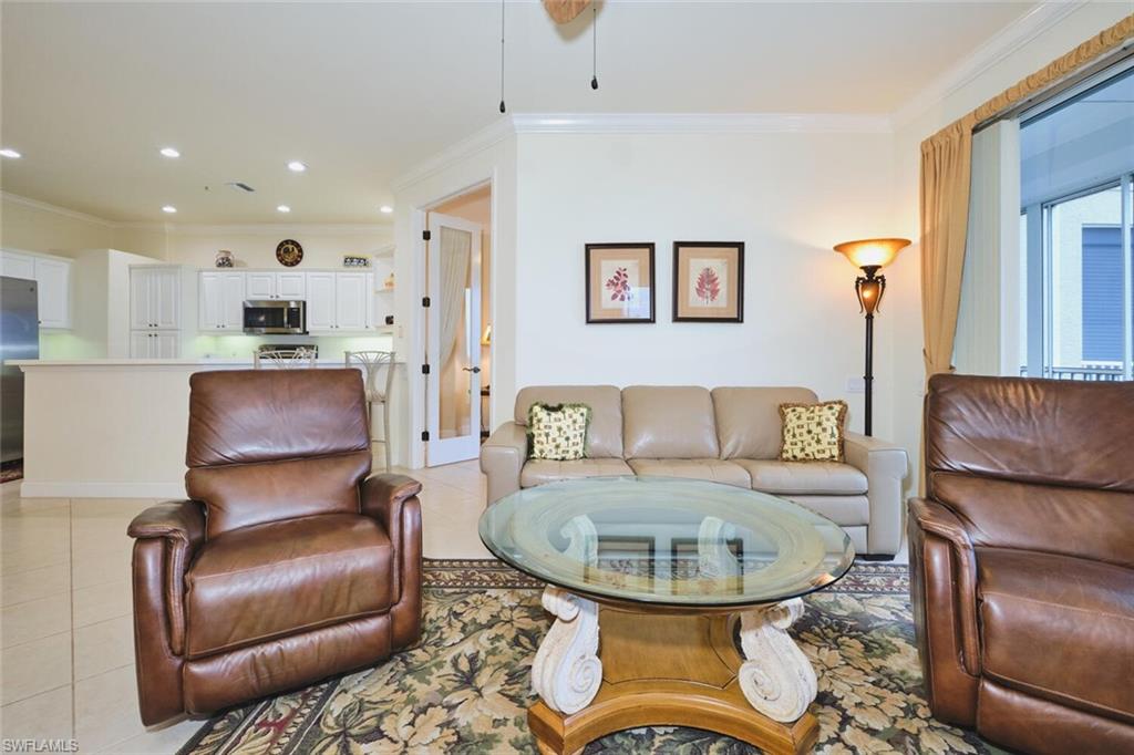 Living room featuring crown molding, light tile patterned floors, and recessed lighting