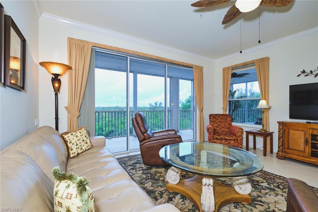 Tiled living room featuring ornamental molding and a ceiling fan