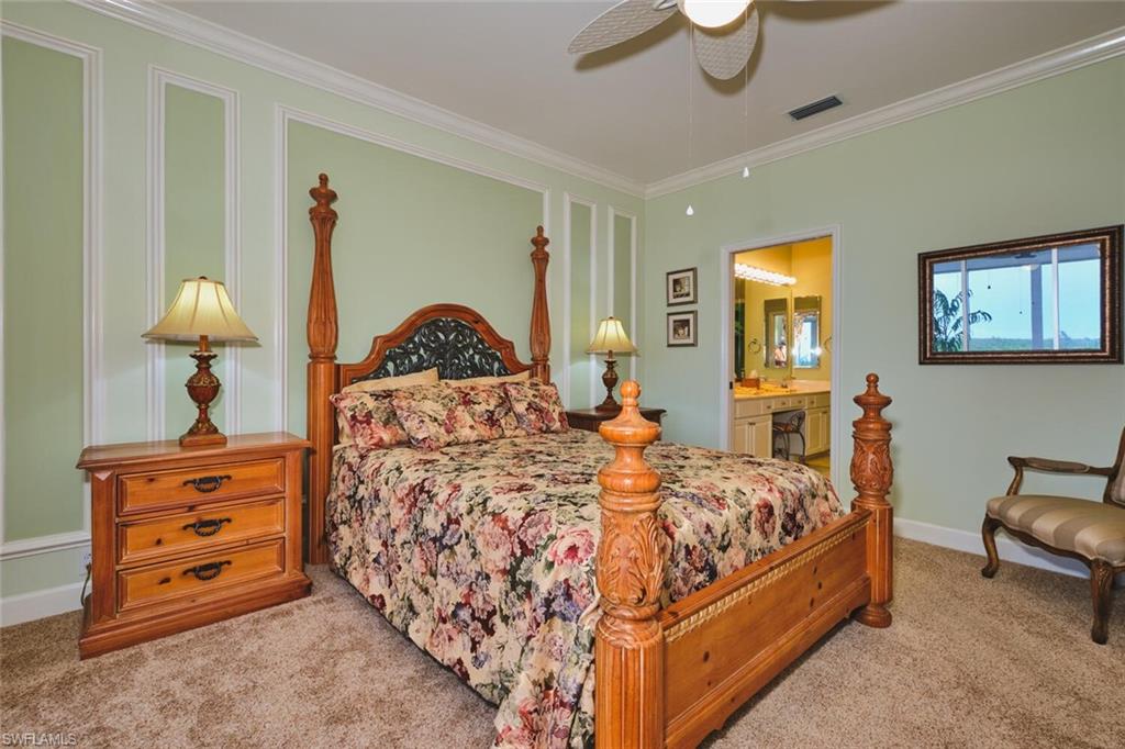 Bedroom featuring crown molding, light carpet, ceiling fan, and ensuite bath