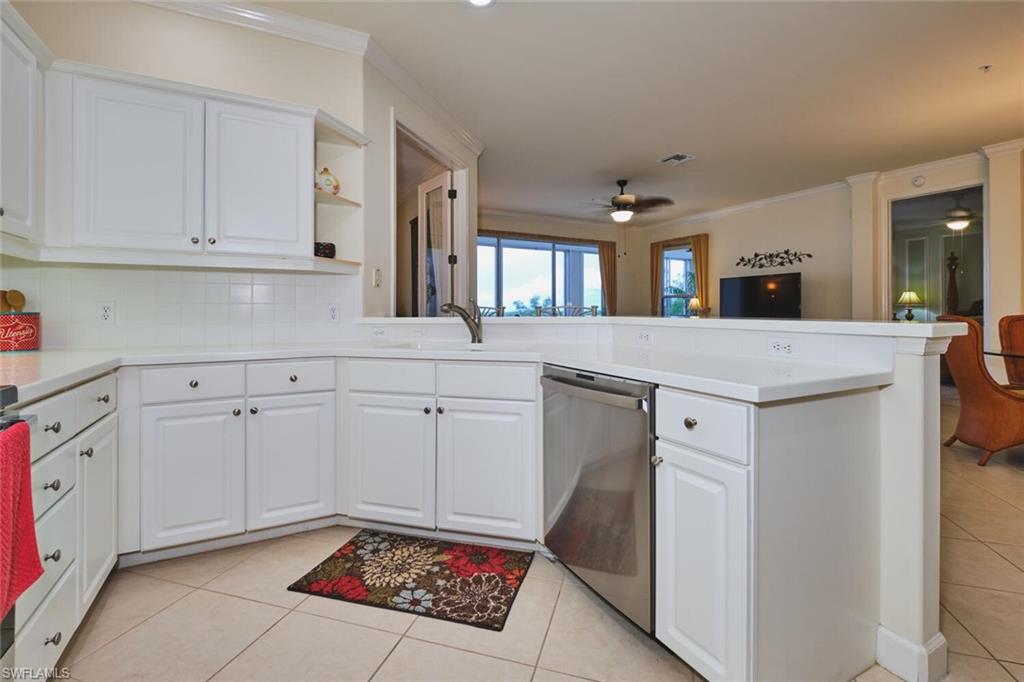Kitchen featuring white cabinets, light tile patterned flooring, a peninsula, open shelves, and ornamental molding