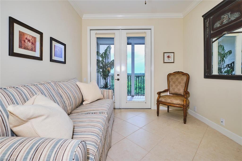 Living room with light tile patterned flooring, crown molding, and french doors
