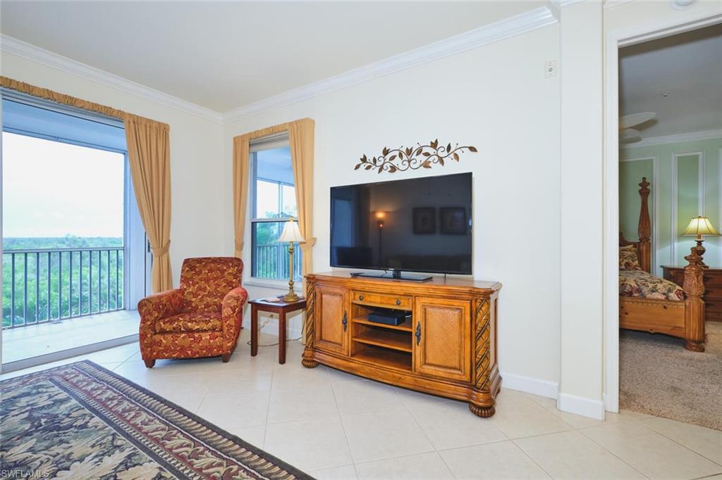 Sitting room featuring crown molding and light tile patterned floors