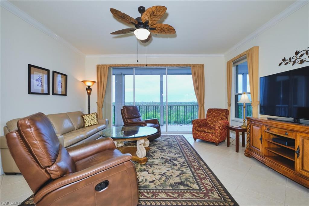 Living area with ornamental molding, light tile patterned flooring, and ceiling fan