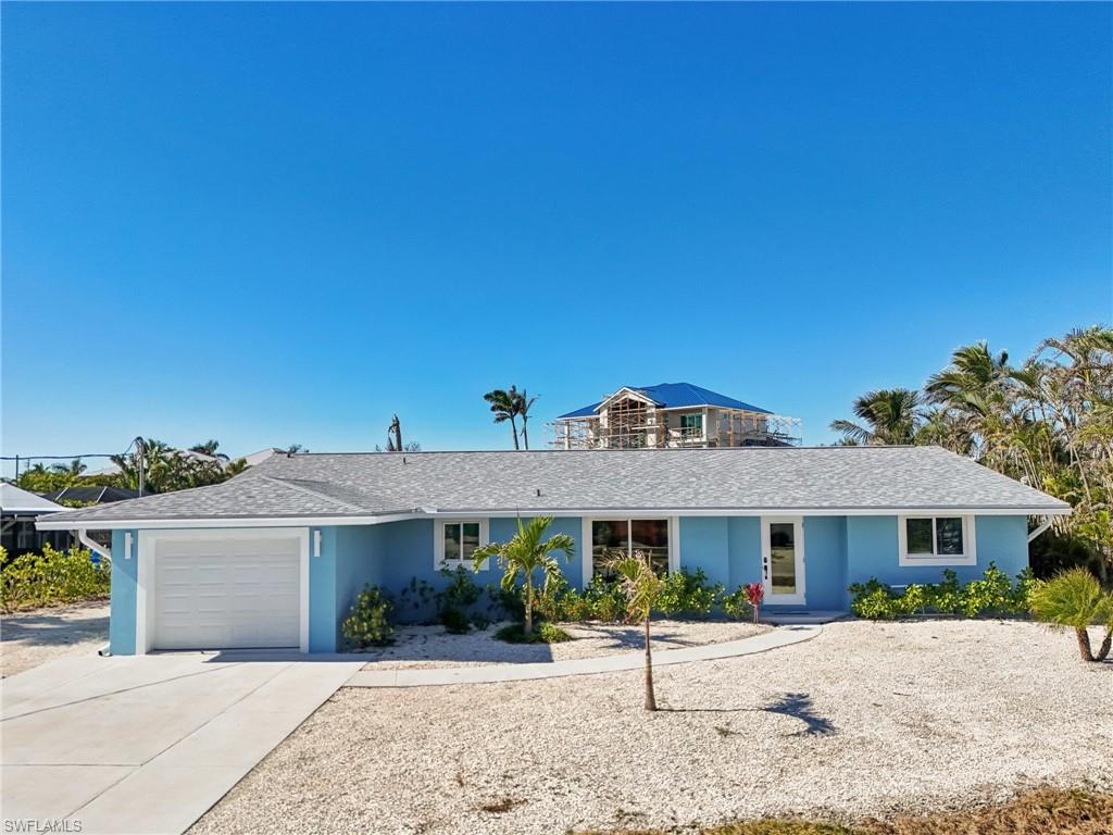 Ranch-style house featuring driveway, an attached garage, stucco siding, and a shingled roof