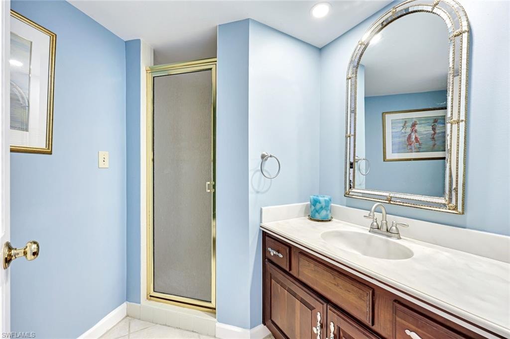 Full bathroom featuring vanity, a stall shower, light tile patterned floors, and recessed lighting